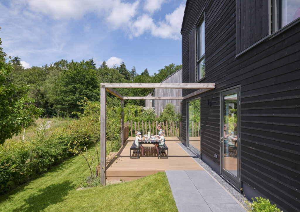 foto tuin houten woning, terras met vlonder en pergola aan wadi